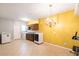 Bright laundry room with yellow accent wall, tile floor, chandelier, washer and dryer, and cabinets at 4381 Prather Son Dr, Loganville, GA 30052