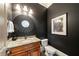 Stylish powder room with a decorative mirror, granite countertop, and modern fixtures at 1207 Thornwell Ne Dr, Brookhaven, GA 30319