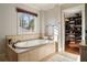 Bright bathroom featuring a soaking tub with tile surround and a view into the walk-in closet at 1207 Thornwell Ne Dr, Brookhaven, GA 30319
