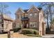 Stately two-story brick home with manicured landscaping and charming architectural details at 1207 Thornwell Ne Dr, Brookhaven, GA 30319