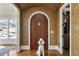 Grand foyer featuring a rustic arched door, hardwood floors, and a unique textured wall finish at 1207 Thornwell Ne Dr, Brookhaven, GA 30319
