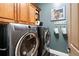 Well-equipped laundry room with front-load washer and dryer, upper cabinets, and decorative laundry accessories at 1207 Thornwell Ne Dr, Brookhaven, GA 30319