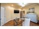 Well-lit home office with hardwood floors, TV, glass-topped desk and decorative display cabinet at 1207 Thornwell Ne Dr, Brookhaven, GA 30319