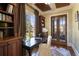 Inviting home office with built-in shelving, coffered ceiling, and french doors leading to sunroom at 1207 Thornwell Ne Dr, Brookhaven, GA 30319