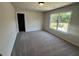 Well-lit bedroom with neutral walls, plush carpet, and a large window offering a pleasant view at 219 Willow St, Canton, GA 30114