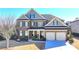 Charming two-story brick home featuring a manicured lawn, a two car garage and welcoming front porch at 3905 Alister Park Dr, Cumming, GA 30040