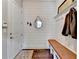 Mud room with shiplap wall accent, coat hooks, bench, and decorative mirror at 3905 Alister Park Dr, Cumming, GA 30040