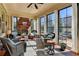 Inviting sunroom featuring a brick fireplace, ceiling fan, and large windows providing ample natural light at 3905 Alister Park Dr, Cumming, GA 30040