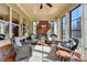 Bright sunroom with brick fireplace, ceiling fan, and black frame windows offering backyard views at 3905 Alister Park Dr, Cumming, GA 30040