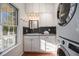 Well-lit laundry room with ample storage cabinets, a sink, and a stacked washer and dryer at 436 Avery St, Decatur, GA 30030