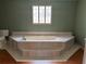 Bathroom featuring a relaxing white tiled soaking tub, perfect for unwinding after a long day at 3290 Spain Rd, Snellville, GA 30039
