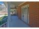 Close-up of a covered porch with brick walls, a ceiling fan, and an elegant front door at 3290 Spain Rd, Snellville, GA 30039