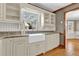 Charming kitchen features a farmhouse sink, granite counters, and white cabinets for ample storage at 3290 Spain Rd, Snellville, GA 30039