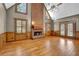 Open living room with a brick fireplace, wood floors, a ceiling fan, and several large windows at 3290 Spain Rd, Snellville, GA 30039