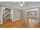 Open-concept living room with hardwood floors, ceiling fan, and views to the staircase and dining room at 3290 Spain Rd, Snellville, GA 30039