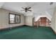 Upstairs loft with a ceiling fan, green carpet, view of the brick chimney below, and windows at 3290 Spain Rd, Snellville, GA 30039