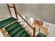 A staircase with wood banister, green carpet and hardwood floors, and a view of the front door at 3290 Spain Rd, Snellville, GA 30039