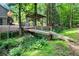 Tranquil backyard area with a wooden bridge, a shaded structure, and lush greenery at 4352 Treeline Way, Douglasville, GA 30135