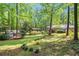 Expansive backyard with lush greenery, mature trees, a wooden pergola, and a storage shed at 4352 Treeline Way, Douglasville, GA 30135