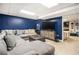 Finished basement with a comfortable gray sectional sofa and a dark blue accent wall at 4352 Treeline Way, Douglasville, GA 30135