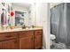 Bathroom with a wood vanity, granite countertop, and a shower/tub combination with a gray shower curtain at 4352 Treeline Way, Douglasville, GA 30135
