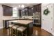 Modern kitchen featuring a center island with seating, stainless appliances, and dark cabinetry at 929 Rolling Branch Way, Lawrenceville, GA 30045