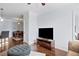 Comfortable living room with wood floors, a tufted ottoman, and views into the dining area and bedroom at 10 Perimeter Summit Ne Blvd # 4243, Brookhaven, GA 30319
