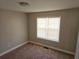 A neutral colored bedroom with carpeted floors and a large window at 1012 Riverclift Dr, Covington, GA 30016