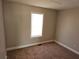 A neutral colored bedroom with carpeted floors and a window at 1012 Riverclift Dr, Covington, GA 30016
