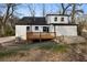 Backyard view showing a two-story house with a wood deck and stone patio at 1870 Avon Sw Ave, Atlanta, GA 30311