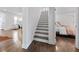 Open hallway with hardwood floors, a staircase, and views into the living room and bedroom at 1870 Avon Sw Ave, Atlanta, GA 30311