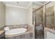 Bathroom features a tiled shower, a soaking tub, and neutral colored walls for a spa like experience at 255 Southerland Ne Ter # 207, Atlanta, GA 30307