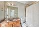 Bathroom with a large mirror, single sink vanity, and tile surround shower with white floral curtain at 255 Southerland Ne Ter # 207, Atlanta, GA 30307