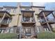 Back exterior view of multilevel townhouse with balconies, patio, and manicured bushes at 255 Southerland Ne Ter # 207, Atlanta, GA 30307