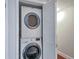 Efficient laundry closet featuring a stacked washer and dryer for space-saving convenience at 86 De Arc Nw Pl, Atlanta, GA 30327