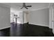 Large, open living room with dark hardwood floors, a ceiling fan, and access to the kitchen at 86 De Arc Nw Pl, Atlanta, GA 30327