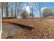 Leafy backyard with an old retaining wall and a satellite dish at 1647 Club Vista Trce, Stone Mountain, GA 30088