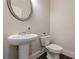 Neat half bathroom has a pedestal sink, toilet, and neutral-colored walls at 614 Denali Dr, Mableton, GA 30126