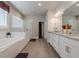 Bright bathroom featuring a glass shower, soaking tub, and double sink vanity at 614 Denali Dr, Mableton, GA 30126