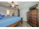 Bedroom featuring a decorative wooden dresser, a ceiling fan and a bed with blue linens and hardwood floors at 614 Denali Dr, Mableton, GA 30126