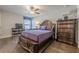 Bedroom features an ornate wood bed frame, hardwood floors, a ceiling fan, and television over a bookshelf at 614 Denali Dr, Mableton, GA 30126