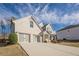 A well-maintained, brick-faced two-story home with a three car garage and a large driveway on a partly cloudy day at 614 Denali Dr, Mableton, GA 30126