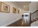 Elegant hallway featuring hardwood floors, decorative wall art, and a staircase with wooden railings at 614 Denali Dr, Mableton, GA 30126