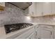 Modern kitchen with stainless steel appliances, white cabinets, and stylish tile backsplash at 614 Denali Dr, Mableton, GA 30126