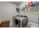 Practical laundry room with modern washer and dryer set, storage basket, and shelving for laundry supplies at 614 Denali Dr, Mableton, GA 30126