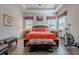 Comfortable bedroom featuring a tray ceiling, exercise bike, and an orange comforter with matching patterned pillows at 614 Denali Dr, Mableton, GA 30126