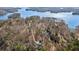 Aerial view showcasing a private residence nestled among trees on a lakefront property at 7530 Heard Rd, Cumming, GA 30041