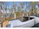 Spacious outdoor deck with seating area, fire pit, grill and beautiful lake views surrounded by mature trees at 7530 Heard Rd, Cumming, GA 30041