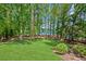 Expansive backyard with manicured lawn, mature trees, and stunning views of the lake at 7530 Heard Rd, Cumming, GA 30041