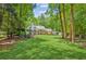 Large backyard with a well-maintained lawn and a view of the house, deck, and surrounding trees at 7530 Heard Rd, Cumming, GA 30041